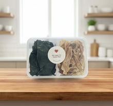 Load image into Gallery viewer, VARIETY PACK - DEHYDRATED DOG TREATS displayed in a clear container on a wooden table.