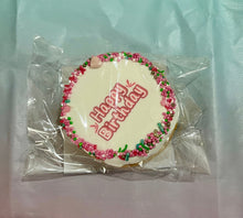 Load image into Gallery viewer, Round cookie with 'Happy Birthday' text on a multi coloured plastic sheet