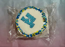 Load image into Gallery viewer, Cookie with 'Happy Birthday' decoration on a clear plastic bag against a coloured background