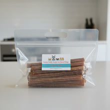 Load image into Gallery viewer, A clear plastic zip-top bag with a handle containing dog chew sticks, placed in front of a black box. The bag has a white and blue label reading ' Aussie Bully Sticks for Small Dogs'