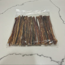 Load image into Gallery viewer, A clear plastic bag filled with multiple long dried bully sticks, laid on a white countertop