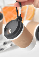Load image into Gallery viewer, Coffee cup dog poo bag dispenser hanging from a clip with a roll of bags included, perfect for pet owners.