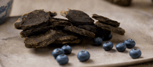 Load image into Gallery viewer, GOURMET DEHYDRATED EMU & BLUEBERRY PATTIES 100g displayed with fresh blueberries on a natural surface.