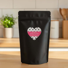 Load image into Gallery viewer, PUMPKIN OAT DOG COOKIES packaged in a black pouch with a heart label on a kitchen counter.