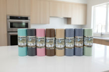 Load image into Gallery viewer, Set of eight rolls of hand tearing bags in various colours on a white surface.

