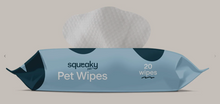 Load image into Gallery viewer, A pack of squeaky pet wipes with a white wipe visible at the top, shown in a light blue wrapper with dark teal accents on a plain beige background.
