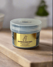 Load image into Gallery viewer, Container of DEHYDRATED DUCK HEARTS dog treats on wooden surface, promoting nutritious animal snacks.
